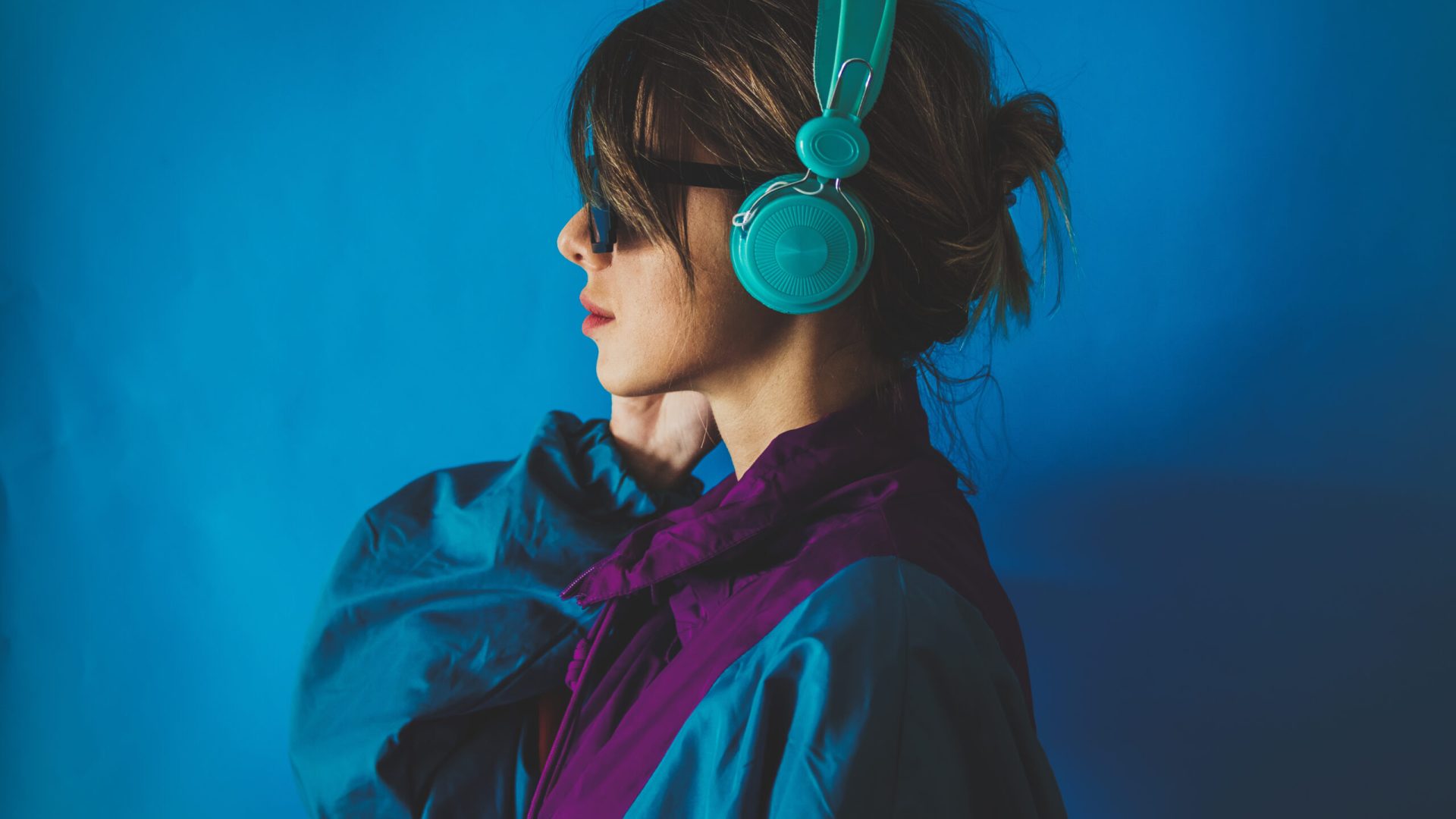 Young woman in 90s style jacket and with headphones